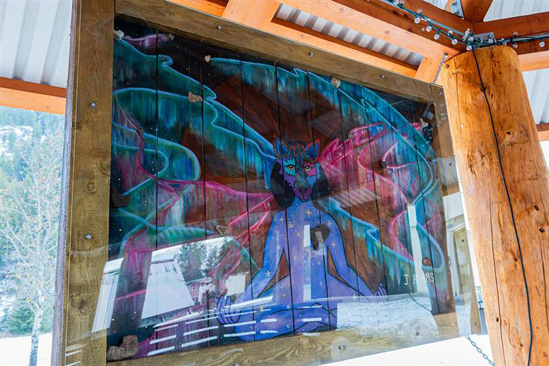 A panel in a wooden structure painted with Indigenous art