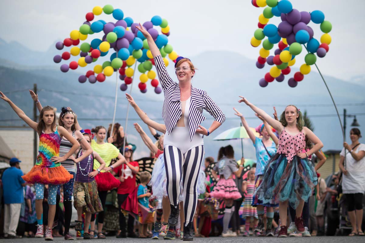 People hold colourful balloons in a parade on the street