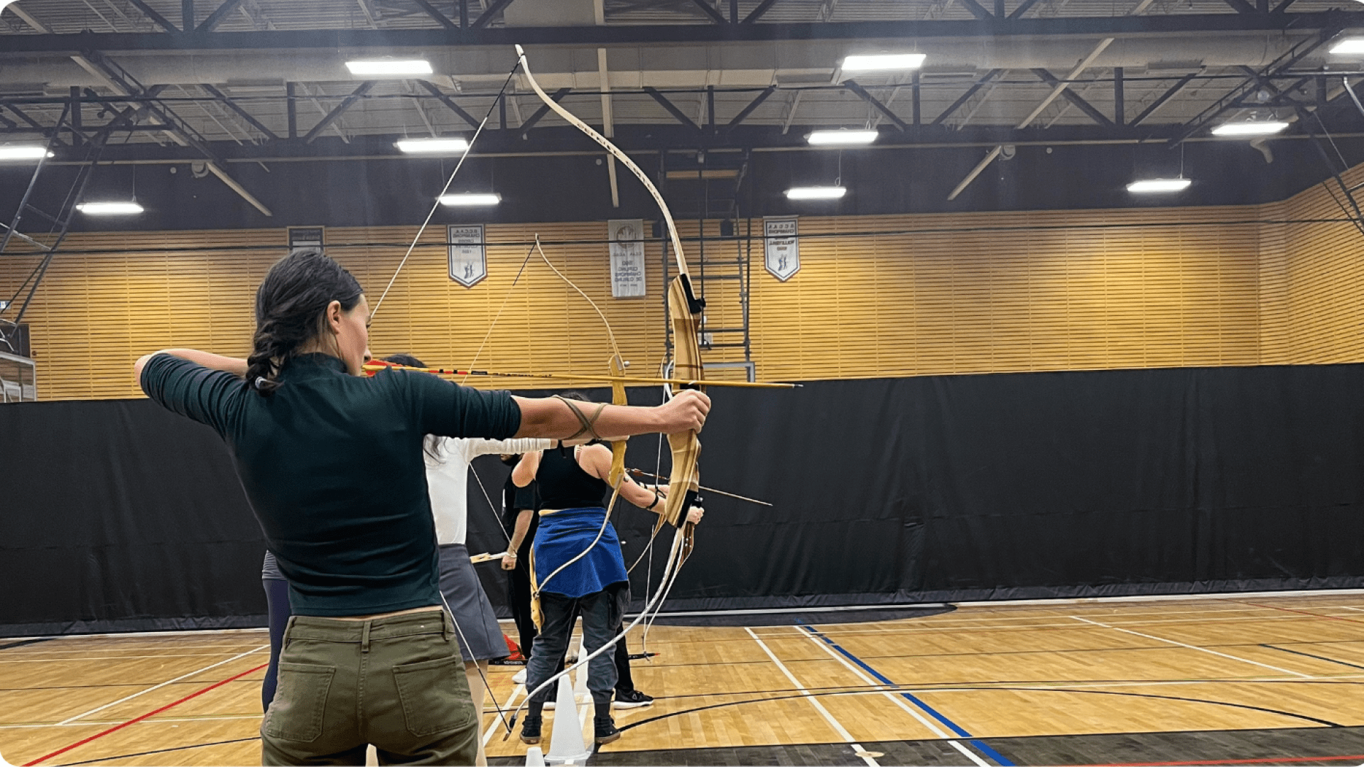 students aiming bows with arrows