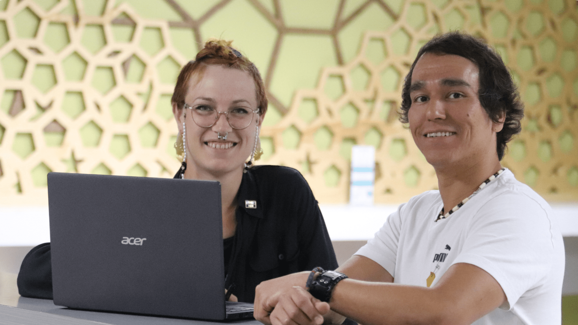 Two students sat behind a laptop at Selkirk College in Trail