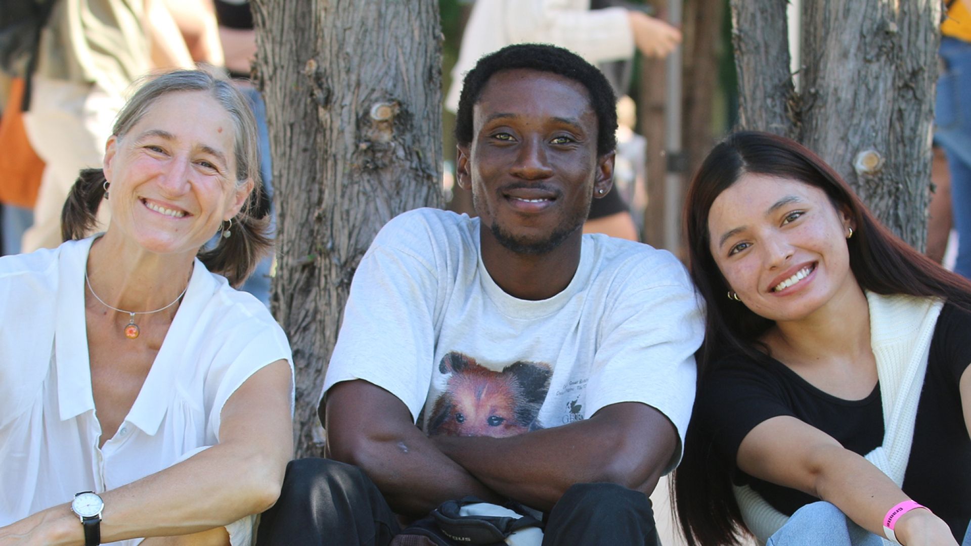 three diverse students sitting under a tree
