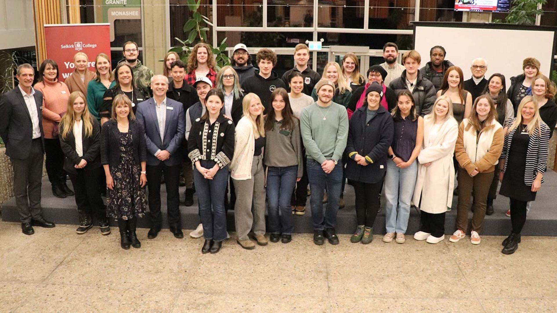 Big group of recipients, Trust staff and college employees on stage