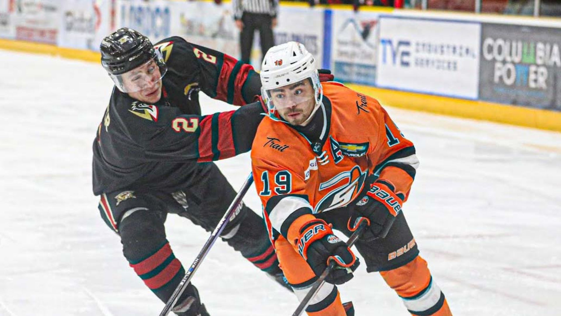 Two hockey players skate on the ice