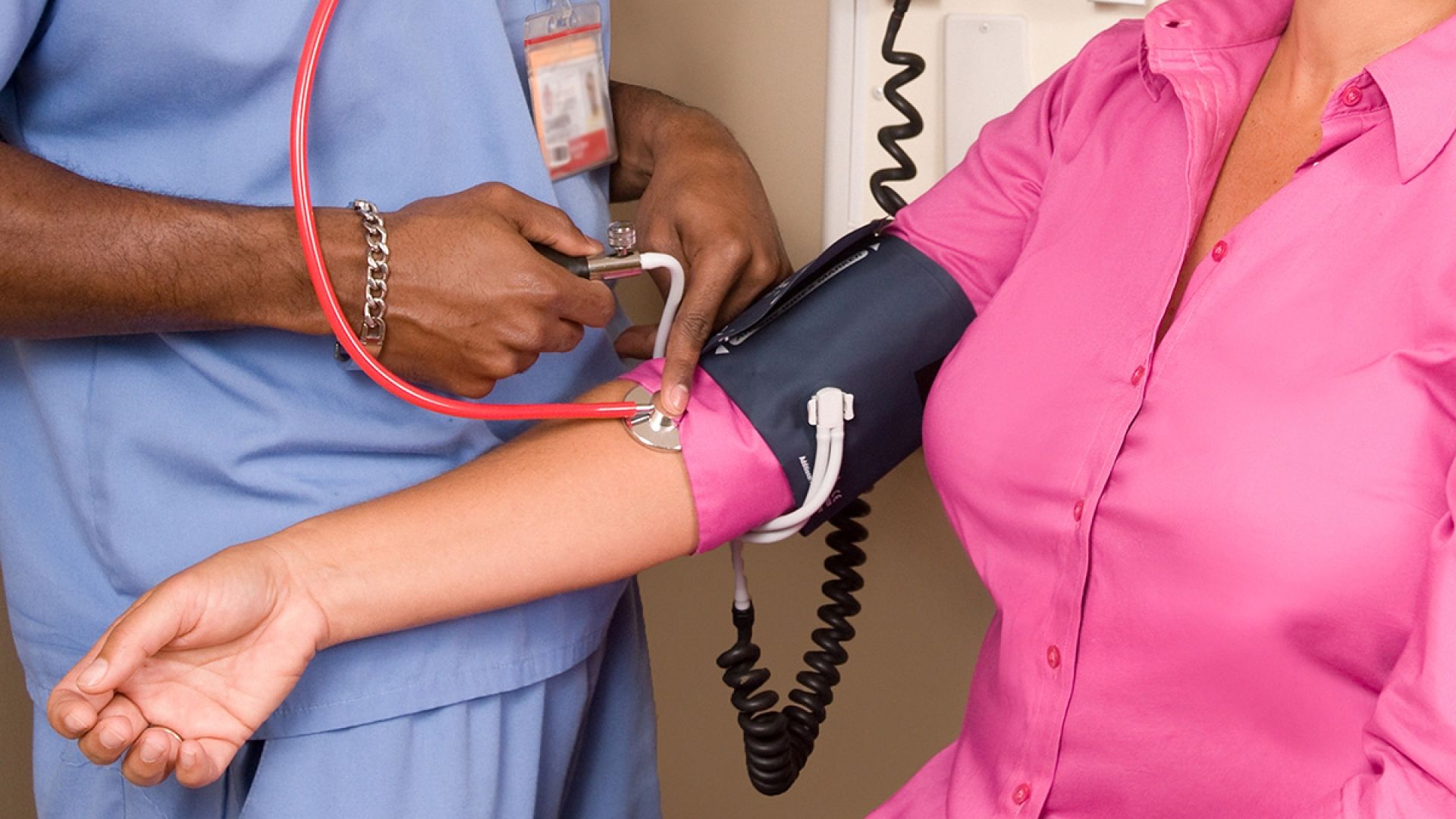 A nurse checks a patient's blood pressure