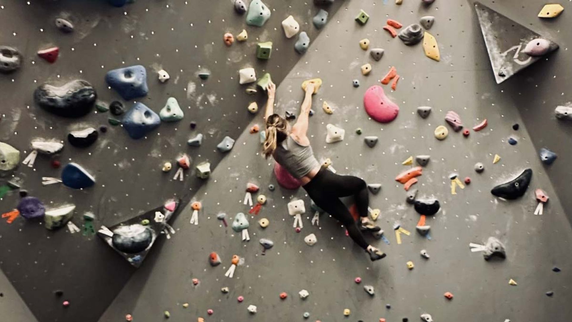 A climber on an indoor bouldering wall