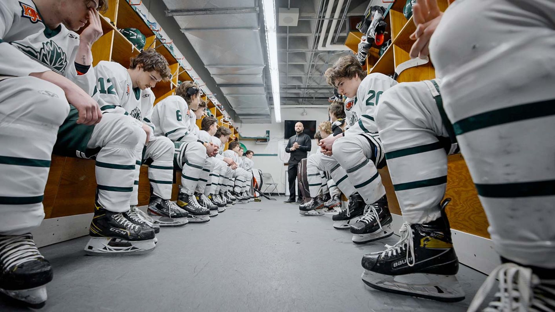 Nelson Leafs players sit on benches in the locker room