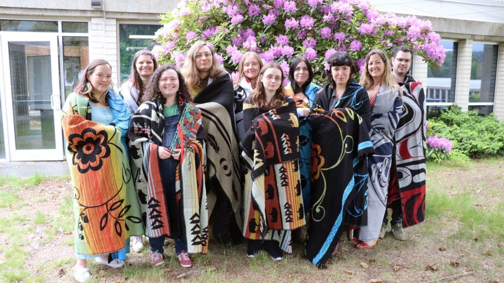 A group of students stand smiling at Indigenous graduation