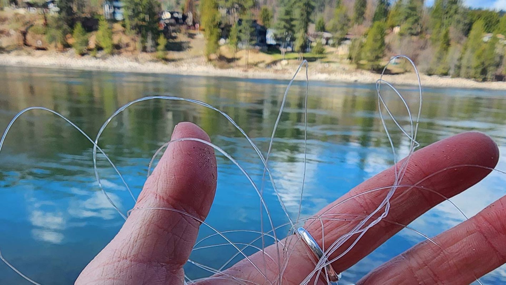A hand holds discarded fishing line