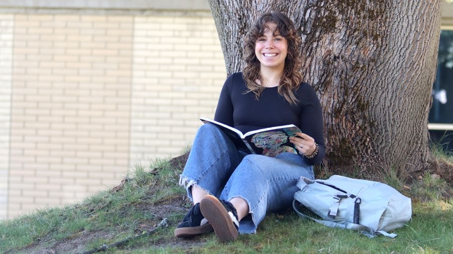 Haley Sluyter reading a book at Castlegar Campus