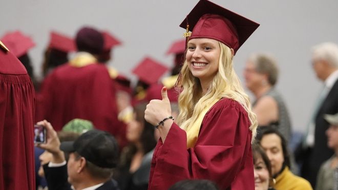 Selkirk College graduate with thumbs up