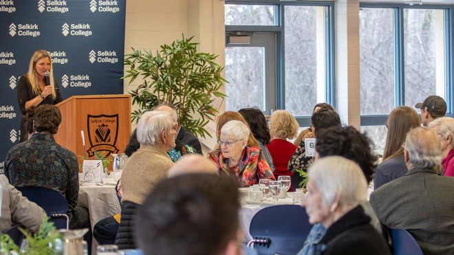 A group of donors sit and listen to a speaker