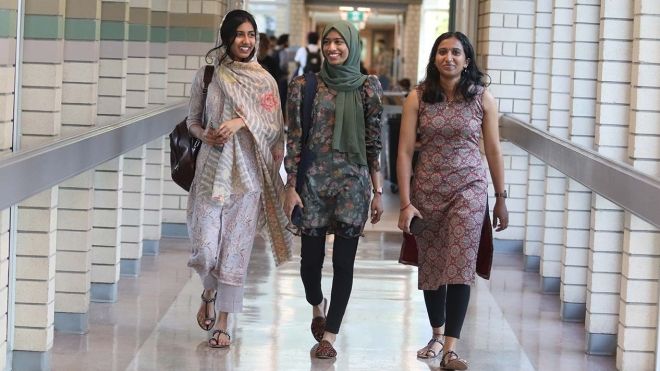 Three international students walking down hallway on the Castlegar Campus