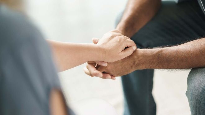 Two people hold hands