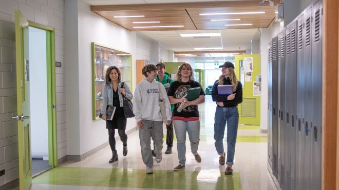 Students walk down the hallway smiling