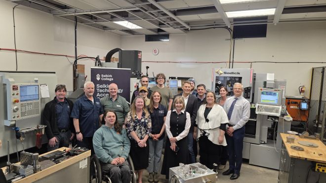 A group of employees and The Honourable Gregor Robertson stand in the STAC