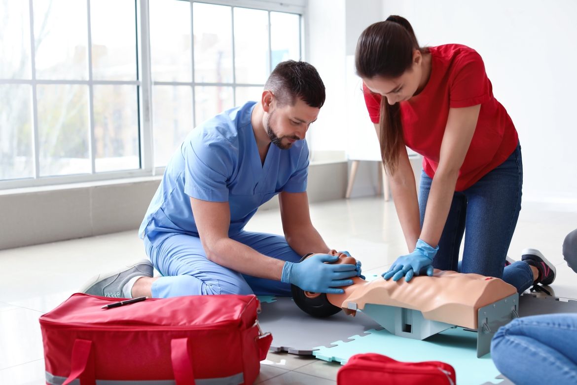 Two people practice first aid on a dummy