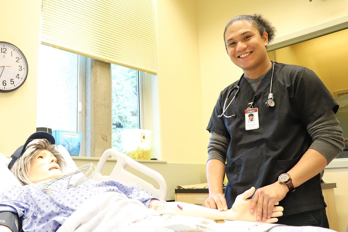 Nursing student checking pulse on a dummy