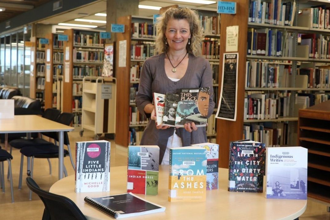 An image of Jennie Barron in the library surrounded by books