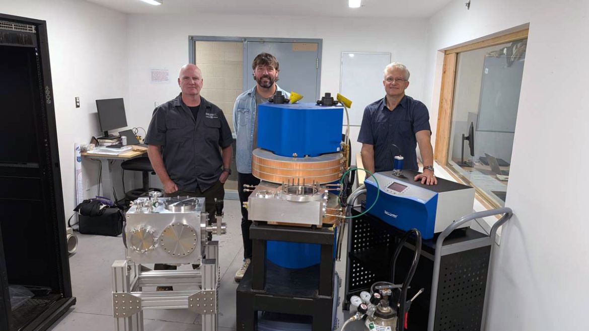 Three people stand with equipment