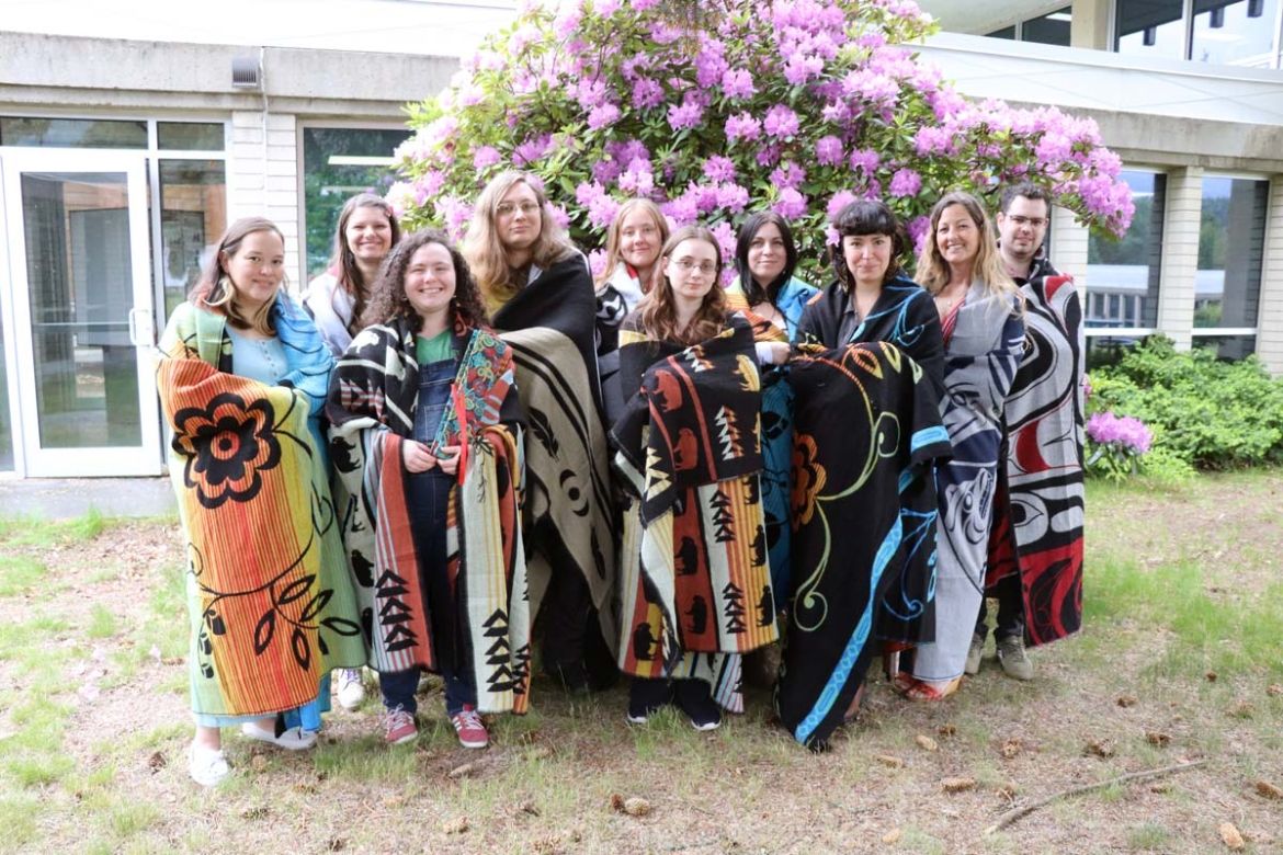 A group of students stand smiling at Indigenous graduation