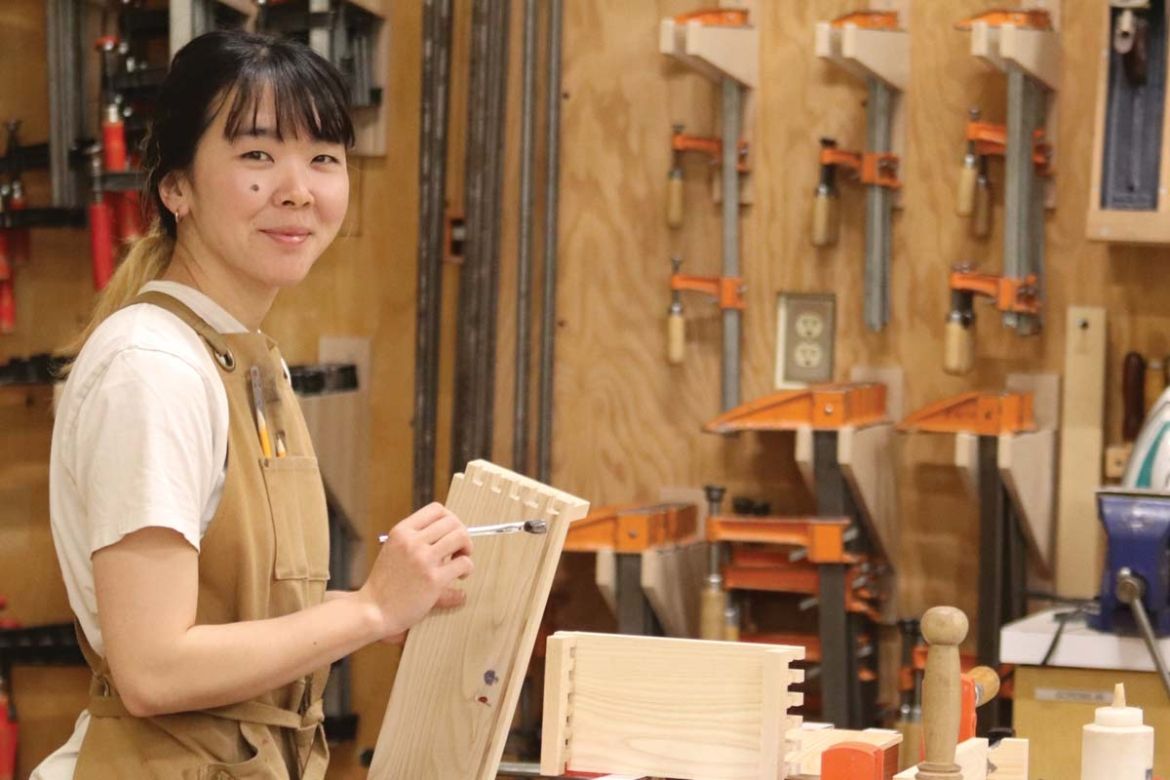 A student works a project in the woodworking studio