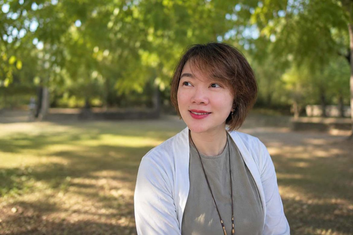 Valedictorian Tianjie Yu sits outside smiling