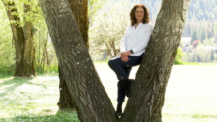 Distinguished Alumni recipient for 2024 Frances Swan stands by a tree on the Castlegar Campus