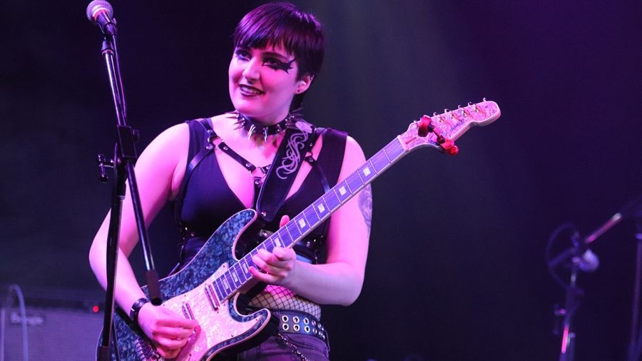 Class of 2024 co-valedictorian Jay Porteous playing guitar on stage