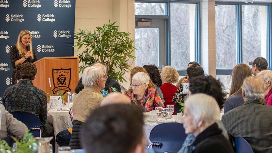 A group of donors sit and listen to a speaker