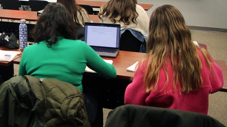 Two students sit in front of a computer