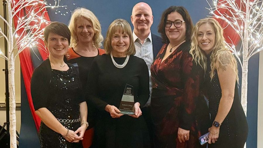 A group of people stand holding an award