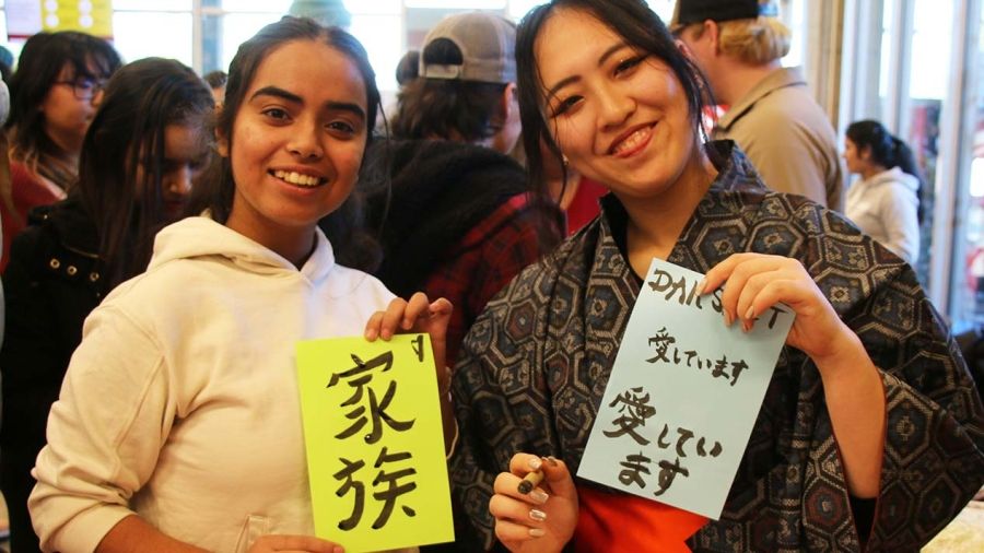 Students at the 2023 Interculturual Fair hold up Japanese writing