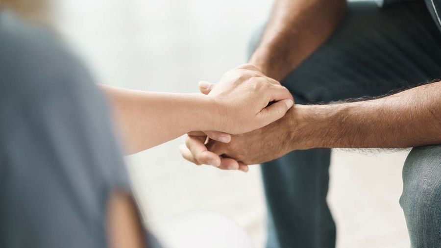 Two people hold hands