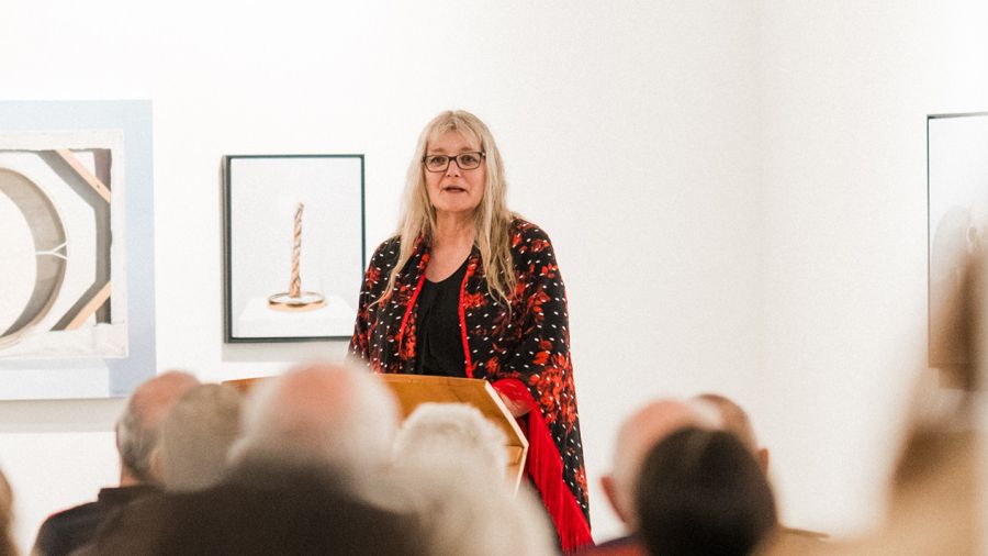 Instructor Michele Morin stands at podium talking