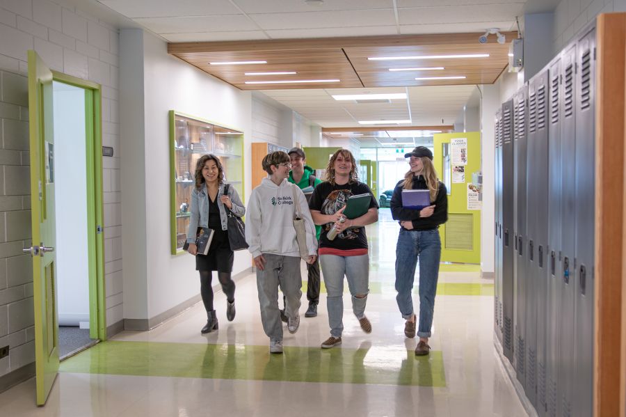 Students walk down the hallway smiling