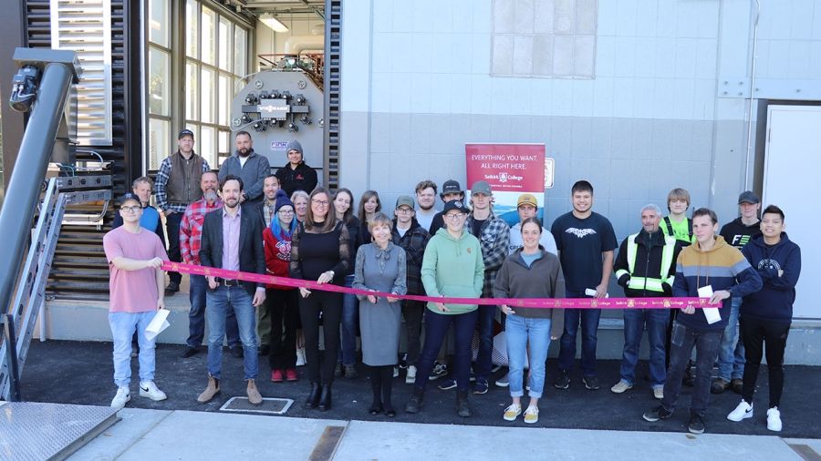 Selkirk College students from the Plant Operator Program join members of the leadership team and contractors in cutting the ribbon on a new biomass boiler located at the Silver King Campus in Nelson.