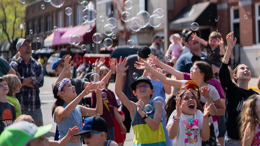 Children chasing bubbles in Trail, the image that is in the 2023 Snapshot cover page