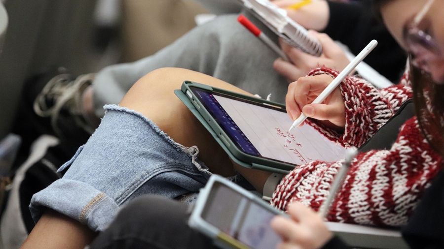 Students sit in class and take notes