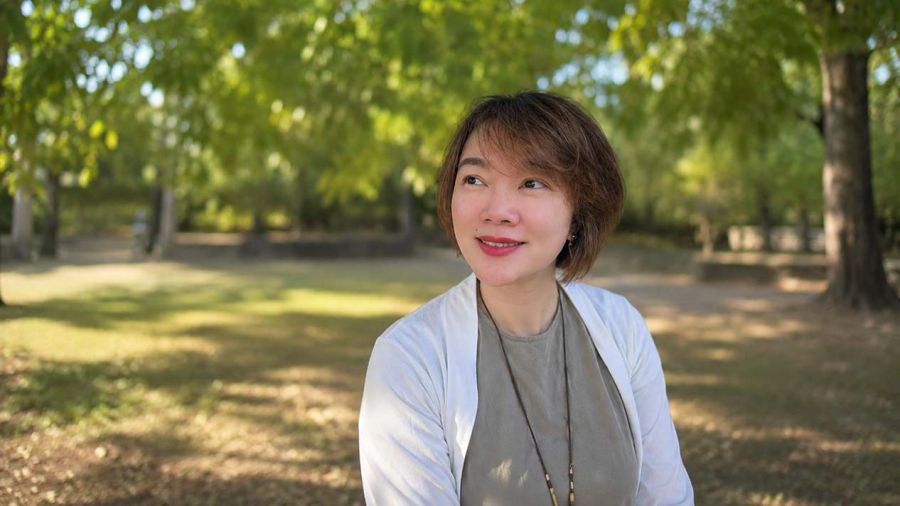 Valedictorian Tianjie Yu sits outside similing