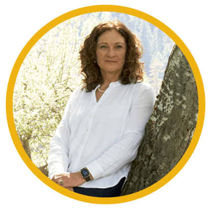 A person leans against a tree