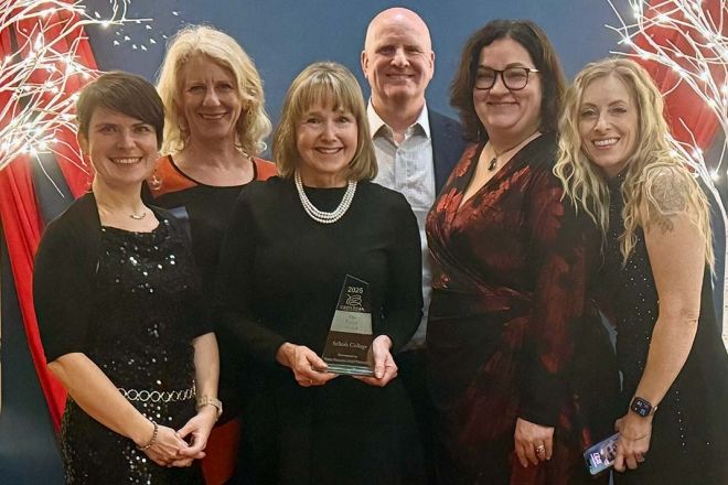 A group of people stand holding an award
