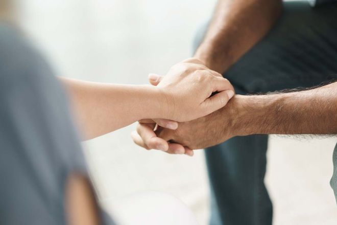Two people hold hands