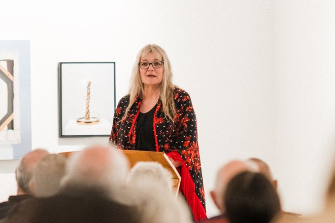 Instructor Michele Morin stands at podium talking