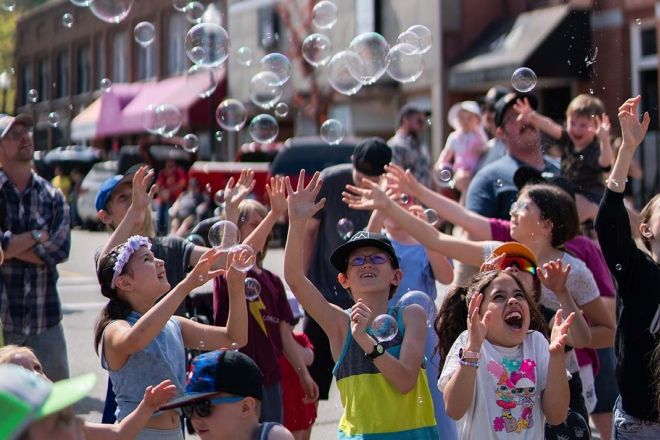 Children chasing bubbles in Trail, the image that is in the 2023 Snapshot cover page