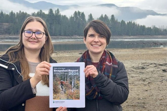 Selkirk Innovates researchers stand outside holding a copy of the Snapshot Report
