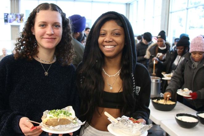 Two students stand and smile