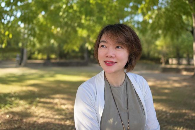 Valedictorian Tianjie Yu sits outside similing